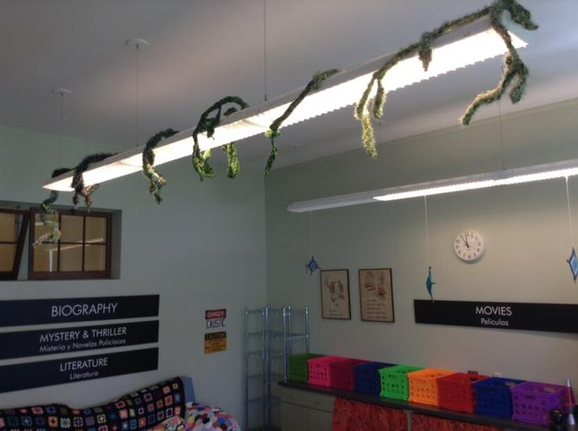 
A custom-made eafy vine of yarn curls around the main light fixture. 
