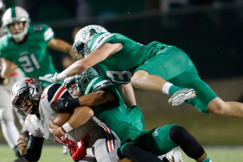Flower Mound Marcus quarterback Xavier Maxwell (15) is tackled by Southlake Carroll...