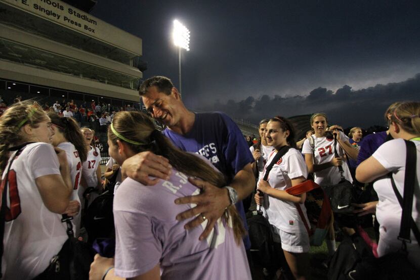 Coppell head coach Chris Stricker gives a hug to the Cowgirls junior goalie Rachel Johnson...