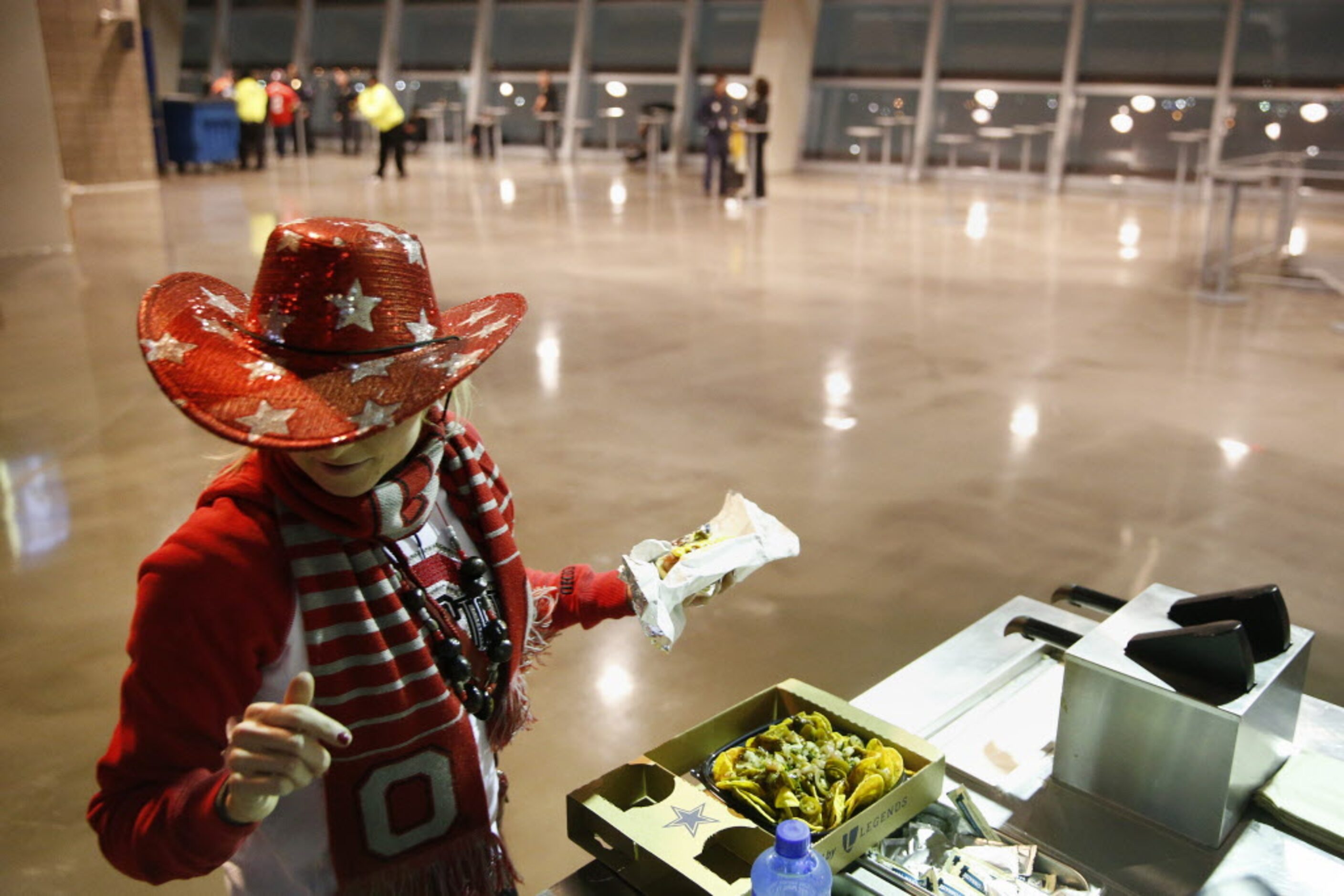 Ohio State Buckeyes fan Kara Gintert, of Irving, Texas, finds napkins for a hotdog and...