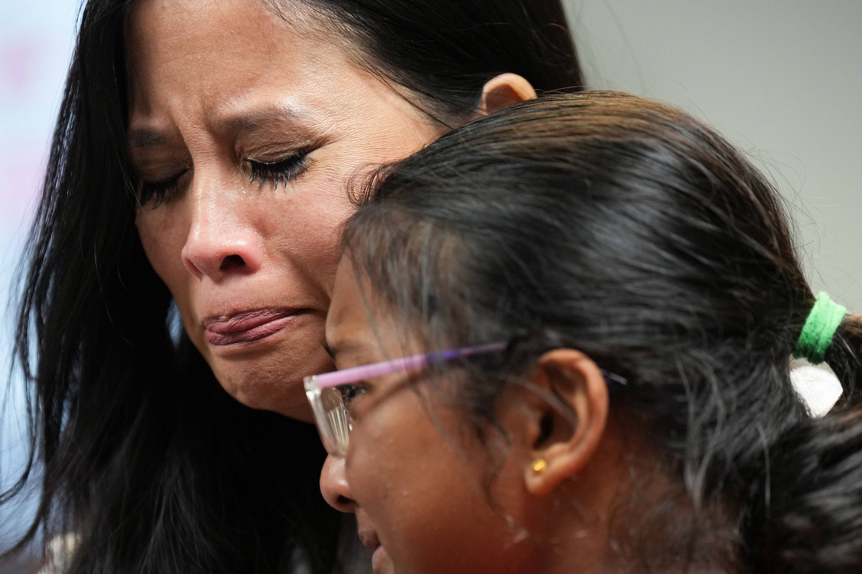 Parent Julie Waters consoles a Pinkerton Elementary School student after a vote to close the...