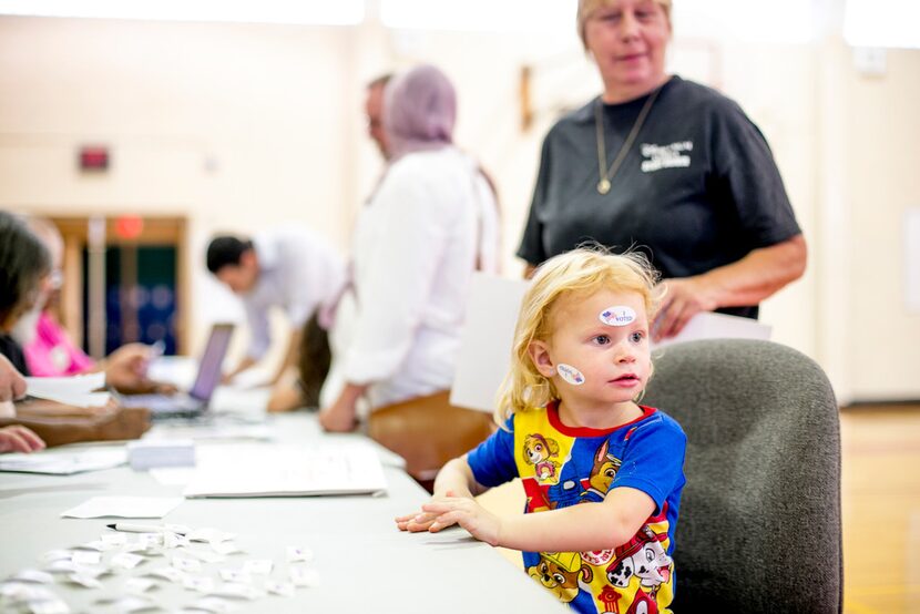 Kiarra Lansing, 3, plays with "I Voted" stickers as her grandparents vote at a polling...