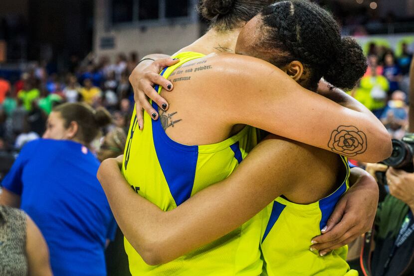 Dallas Wings center Liz Cambage (8), left, embraces forward and center Azurâ¡ Stevens (30)...