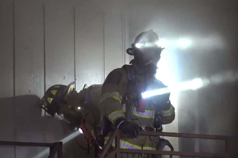 Firefighters emerge from a smoke-filled apartment unit Tuesday morning in Euless.