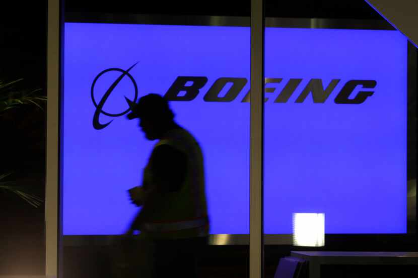 A worker walks in front of a sign at Boeing's 737 delivery center at Boeing Field in Seattle. 