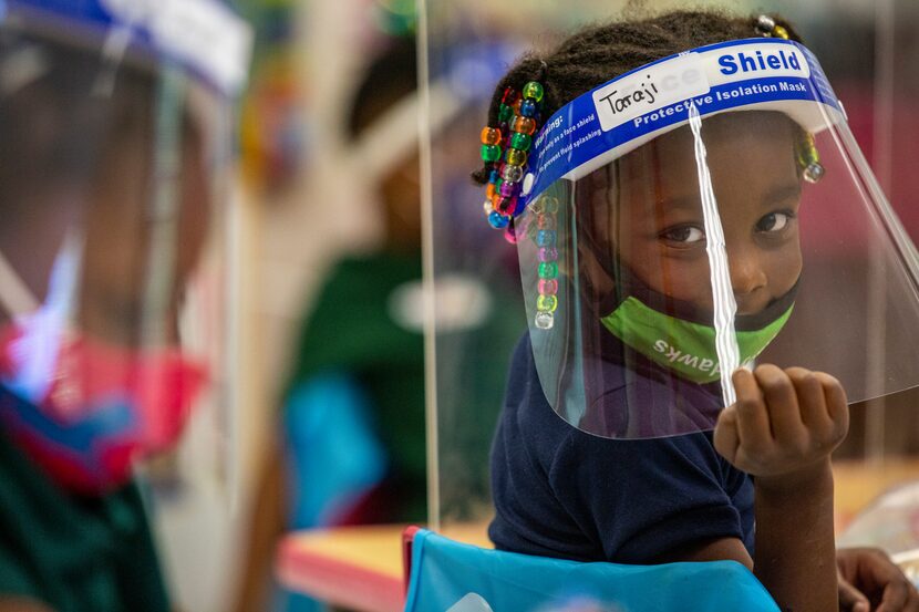 Pre-K 4 student Taraji Thomas poses for a portrait while working on an activity behind a...