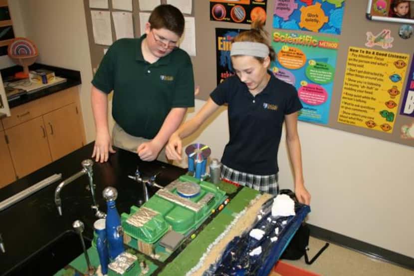 Dallas Academy seventh graders Joshua Hargrove and Virginia Addison work on Traverse-City,...