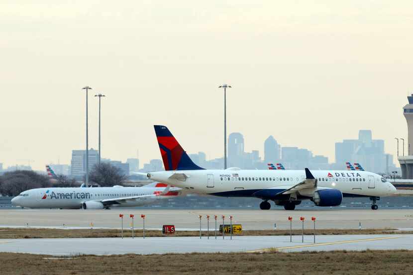 A Delta Airlines aircraft and an American Airlines aircraft wait to take off at DFW...