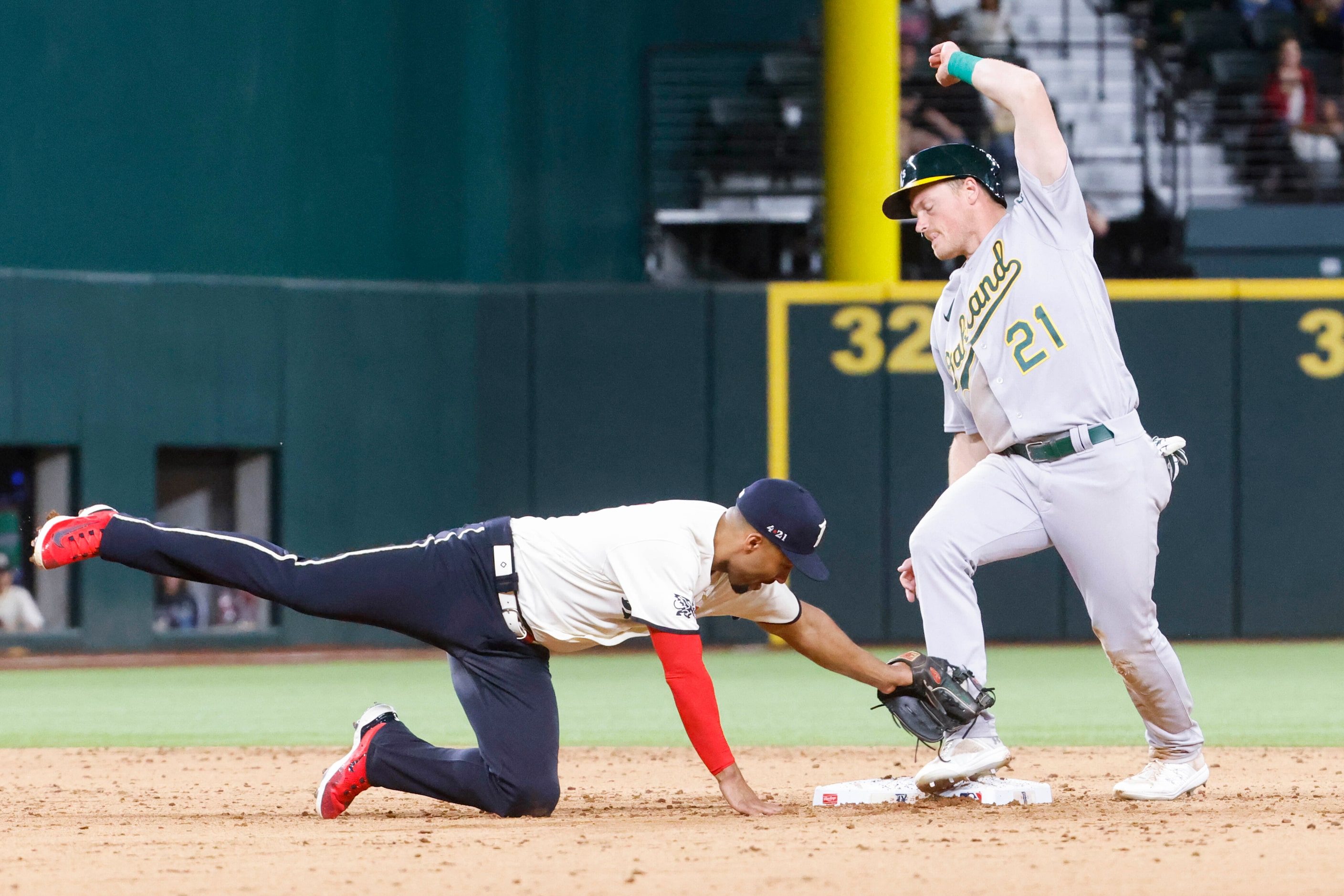 Texas Rangers second baseman Marcus Semien (left) attempts to tag Oakland Athletics left...