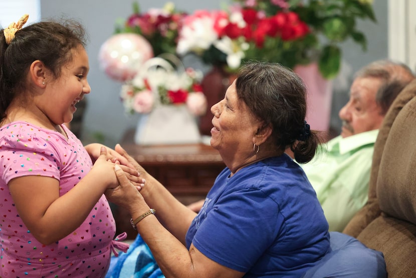 Josefina Montelongo, (centro), madre de Juan Montelongo, interactúa con su nieta Ingrid...