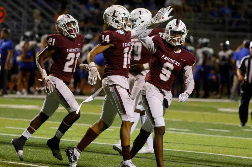 Lewisville wide receiver Kye Stone (14) gets congratulated by Armani Winfield after scored...