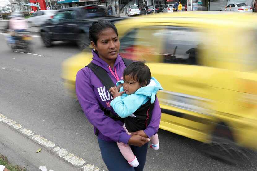 Jenifer Salas, de 27 años y originaria de Venezuela, carga a su bebé mientras pide ayuda en...