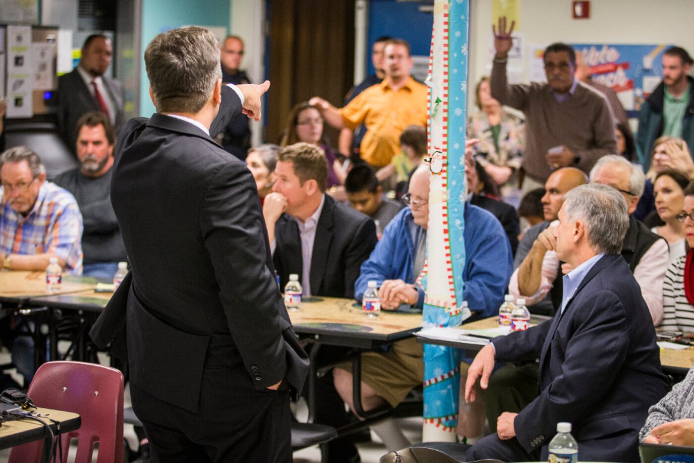 DISD chief operating officer Scott Layne (standing at left) and trustee Dan Miccishe (seated...