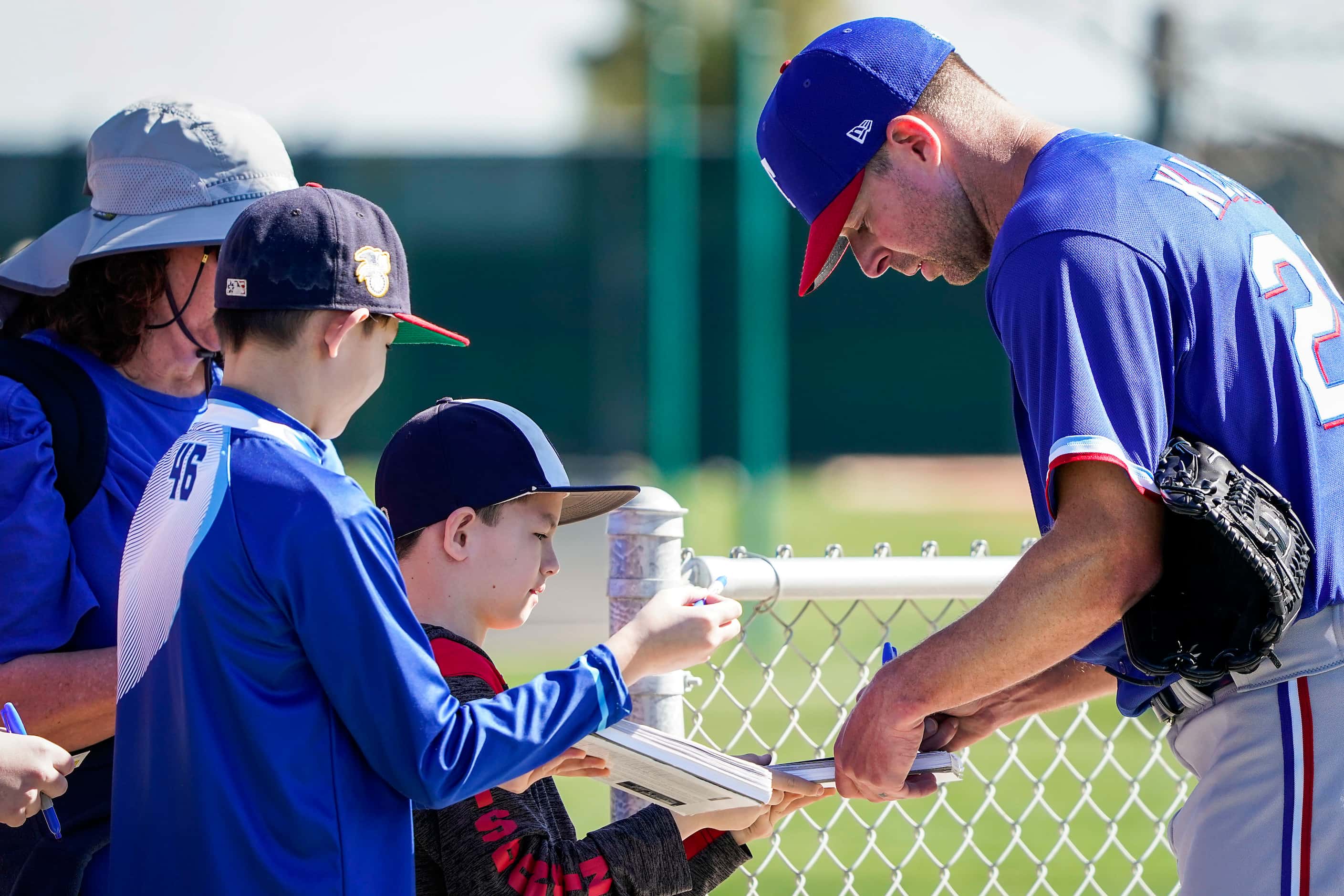 Texas Rangers pitcher Corey Kluber signs autographs during a spring training workout at the...