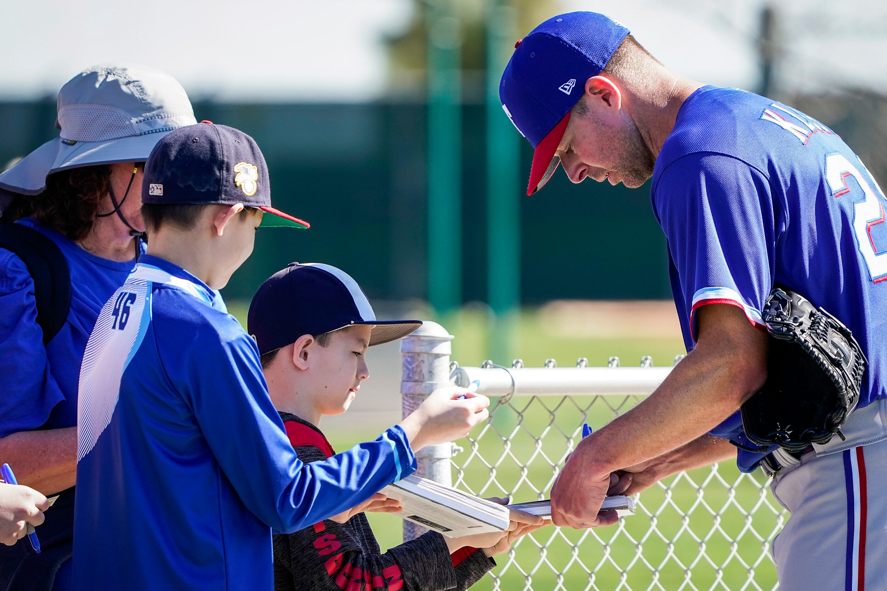 Texas Rangers pitcher Corey Kluber signs autographs during a spring training workout at the...