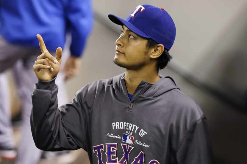 Texas Rangers pitcher Yu Darvish gestures in the dugout during a baseball game against the...
