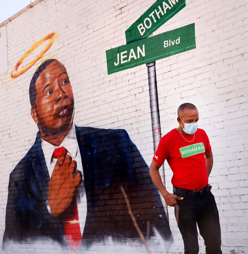 Bertrum Jean takes a moment for himself as he views a mural of his slain son, Botham Jean,...