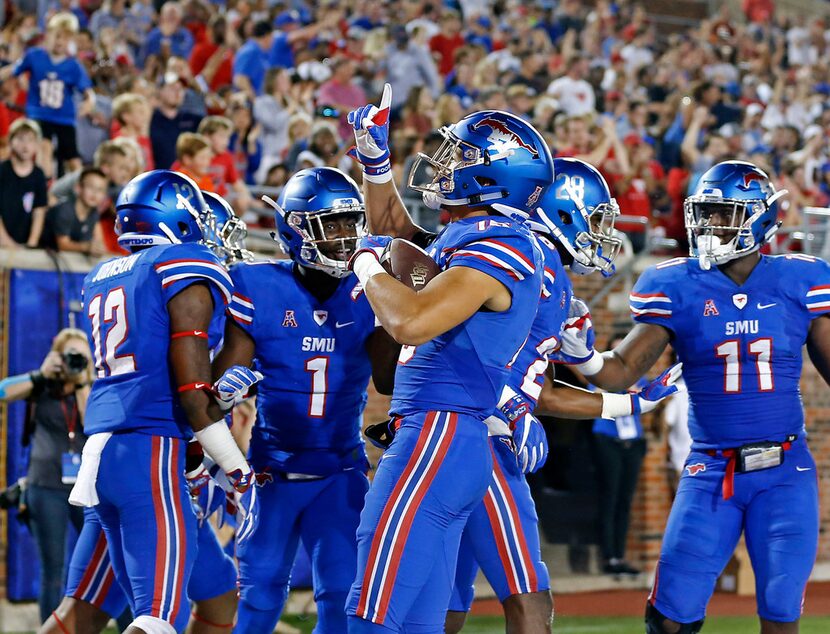 SMU defensive back Jordan Wyatt (15) celebrates with his teammates after he returns an...