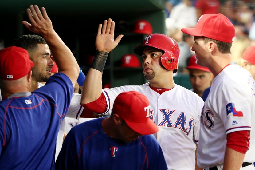Texas Rangers right fielder Carlos Beltran (36) is congratulated by teammates after he...