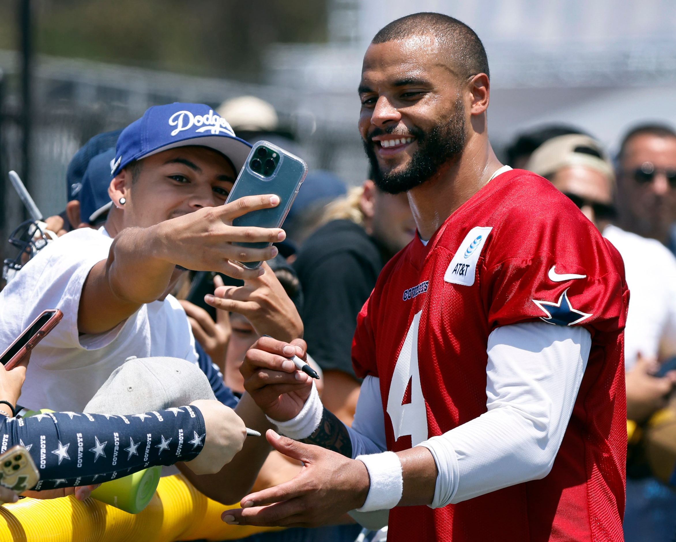 Dallas Cowboys quarterback Dak Prescott (4) poses for a photo with a fan as he signed...