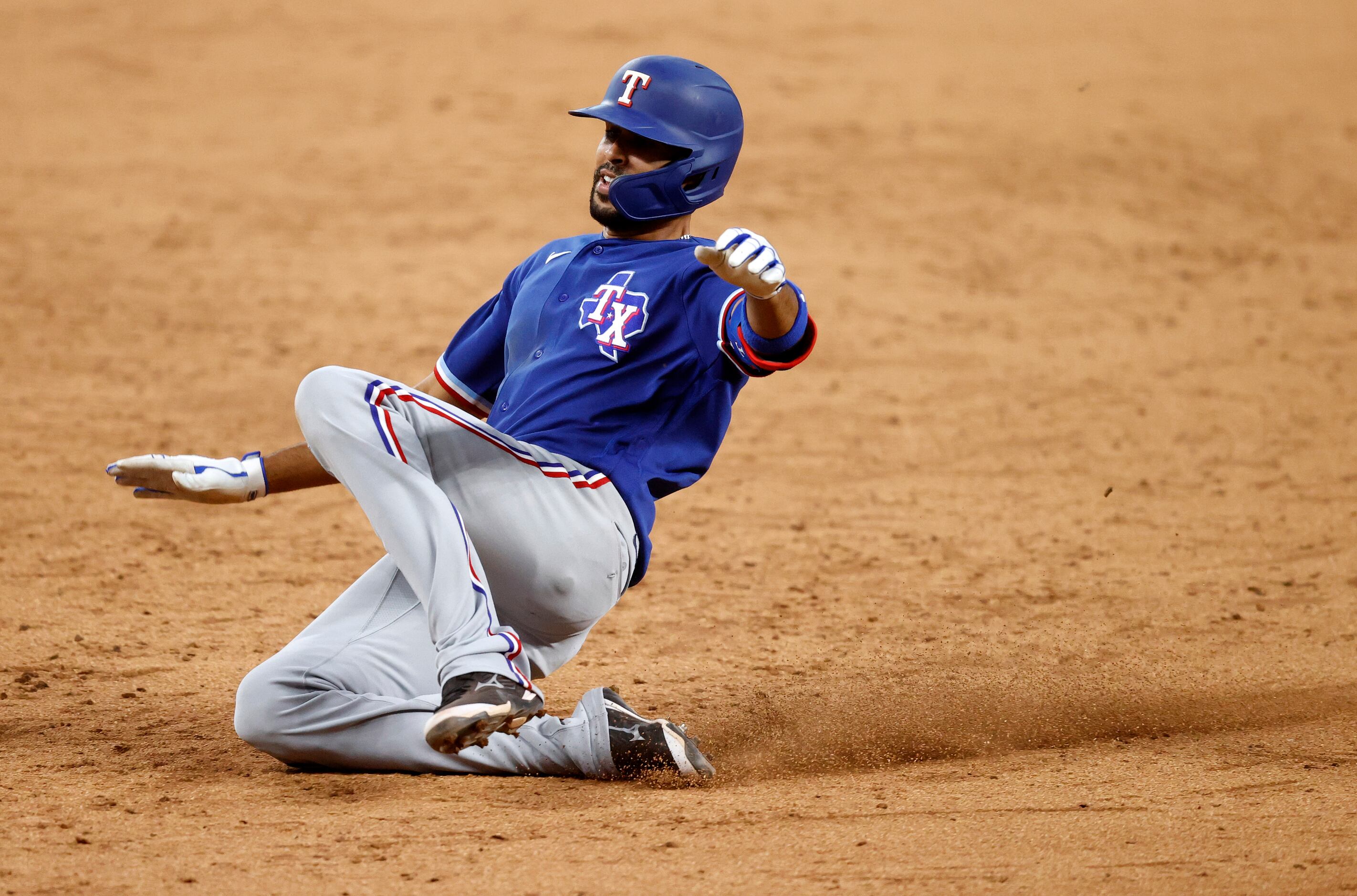 Texas Rangers Yadiel Rivera slides into third base for a triple during an intrasquad Summer...