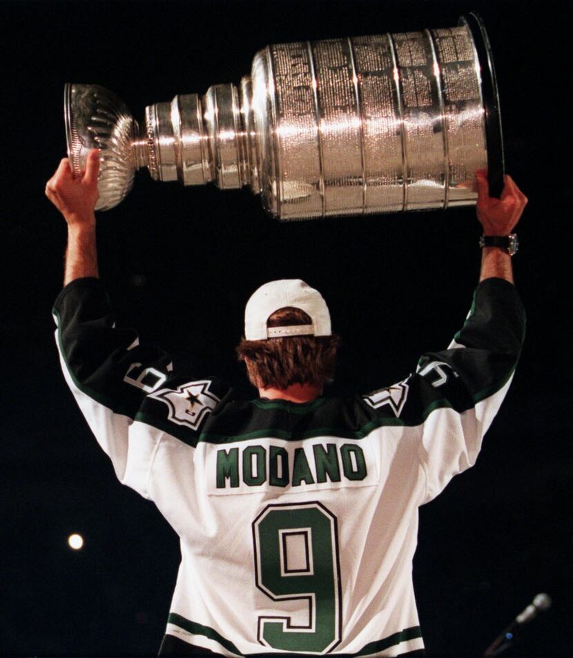 Dallas Stars' Mike Modano hoists the Stanley Cup over his head during a ceremony at Reunion...