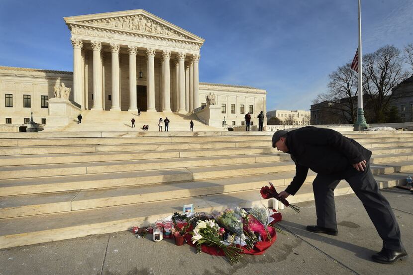  James Peck of Springfield, Va., lays flowers at a makeshift memorial for Supreme Court...