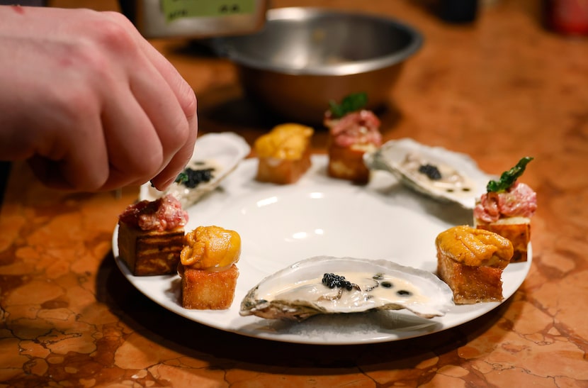 Georgie executive sous chef Reilly Brown plates a dish of treats, including a caviar-topped...