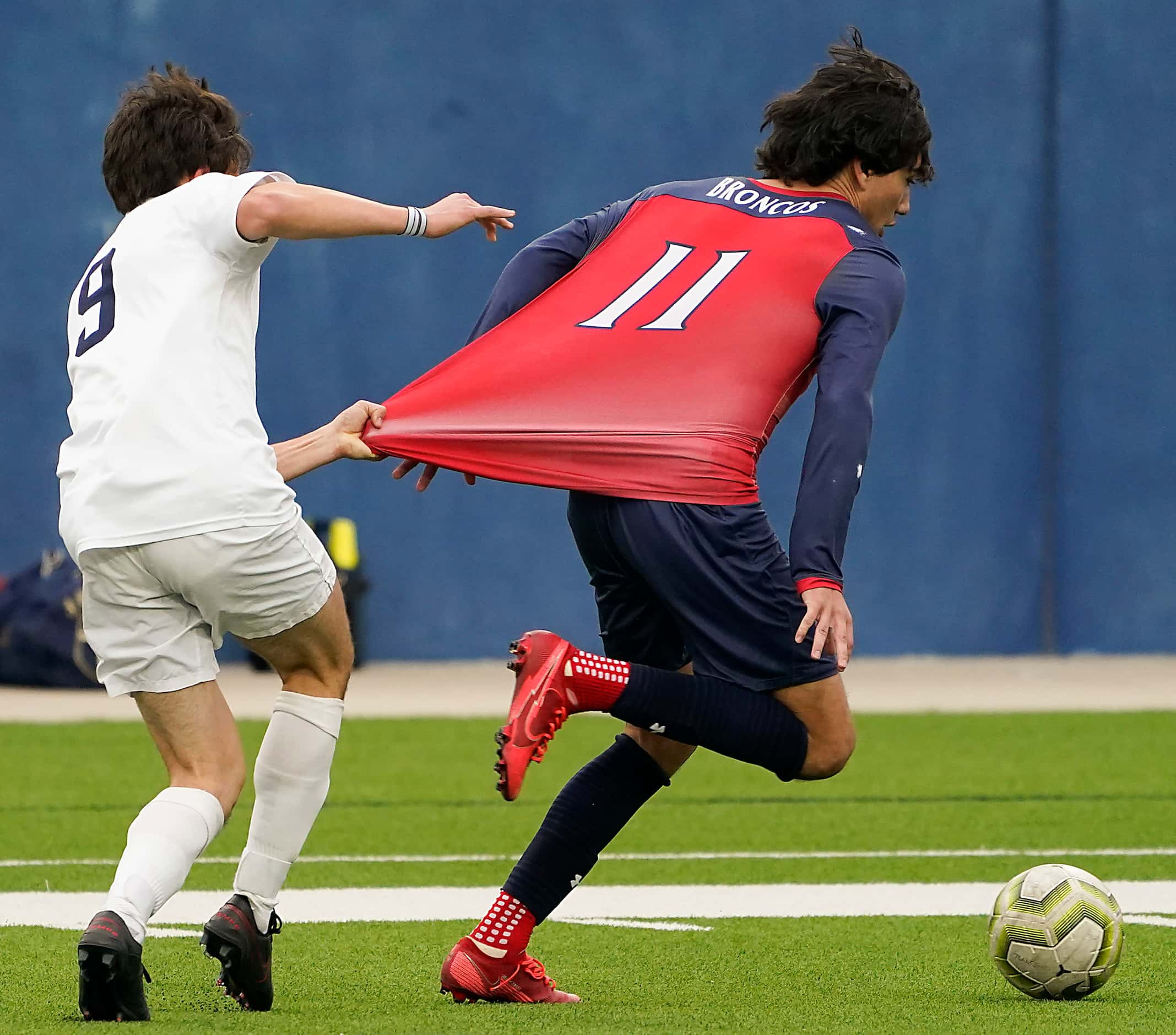 McKinney Boyd forward Jonathan Marquez (11) is pulled down by Jesuit midfielder Grant...