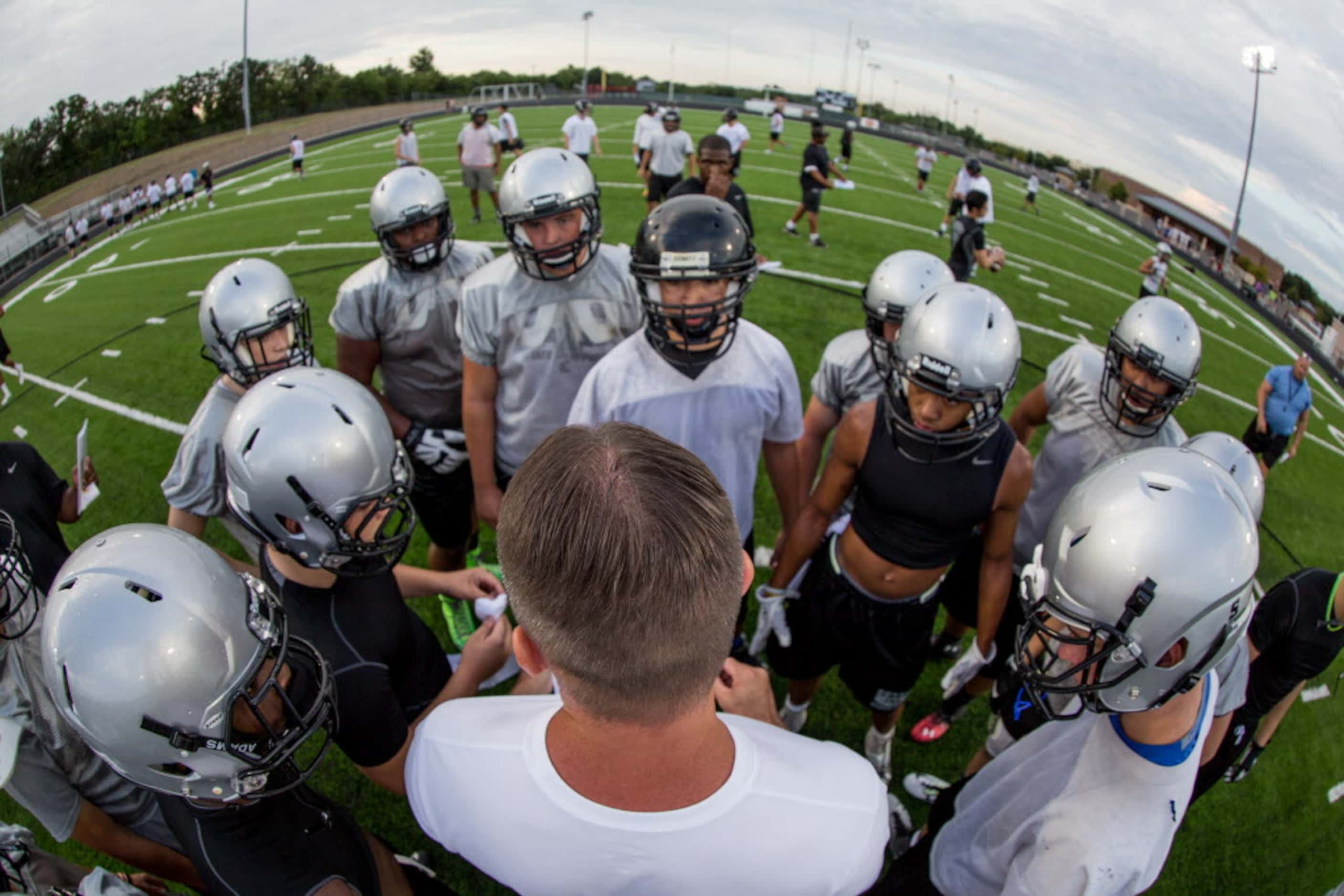 Denton Guyer head football coach John Walsh commands the huddle during the first day of...