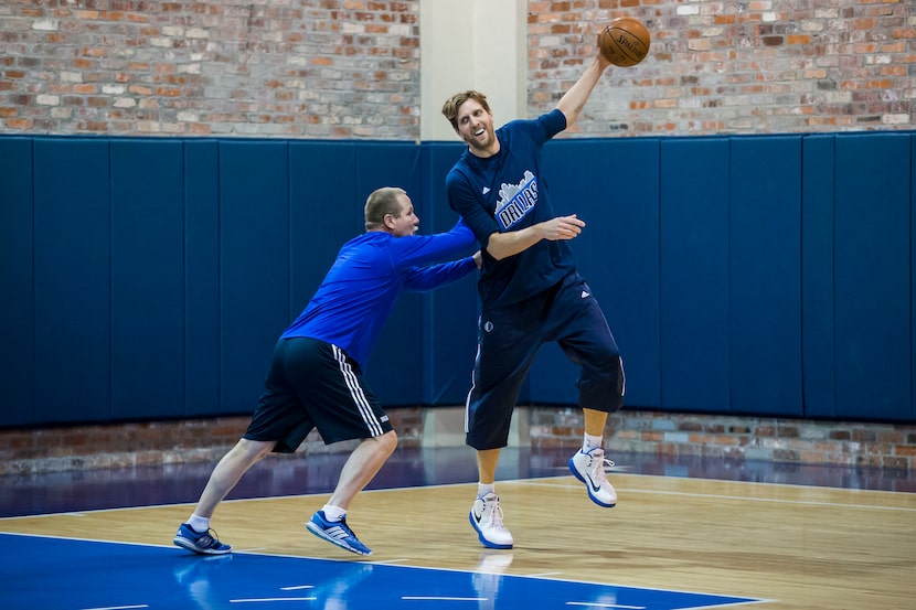 Dallas Mavericks forward Dirk Nowitzki warms up with player development coach Brad Davis on...