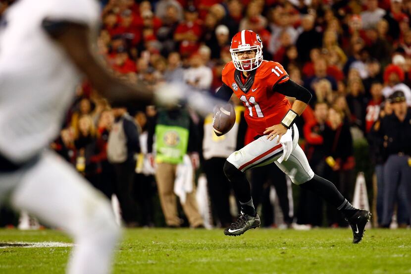 Greyson Lambert #11 of the Georgia Bulldogs scrambles on a pass play during the first half...
