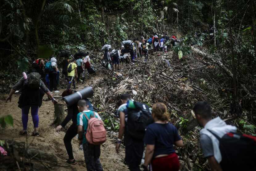 Un grupo de migrantes atraviesa el Tapón del Darién desde Colombia hacia Panamá con miras a...