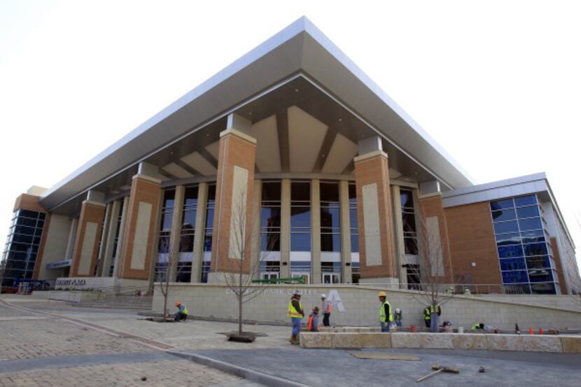 Workers put the final touches around the new College Park Center on the campus of the...