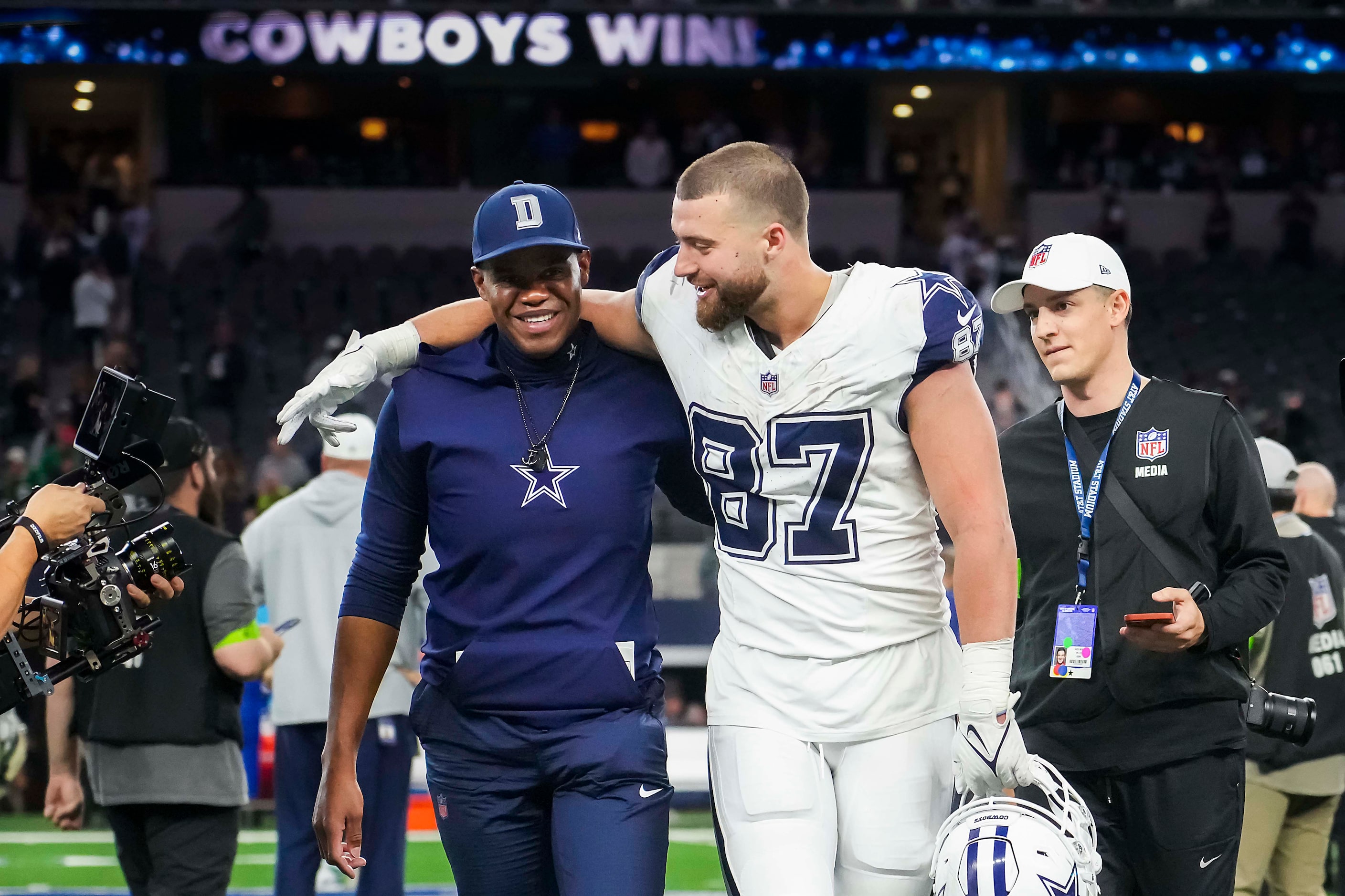 Dallas Cowboys tight end Jake Ferguson (87) puts his arm around tight ends coach Lunda Wells...