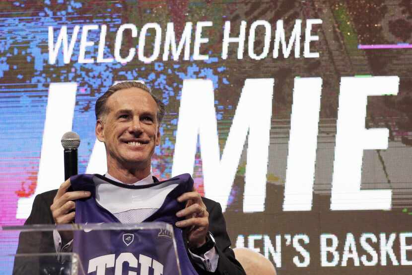 TCU's new men's basketball coach Jamie Dixon holds up a jersey  after he was introduced...