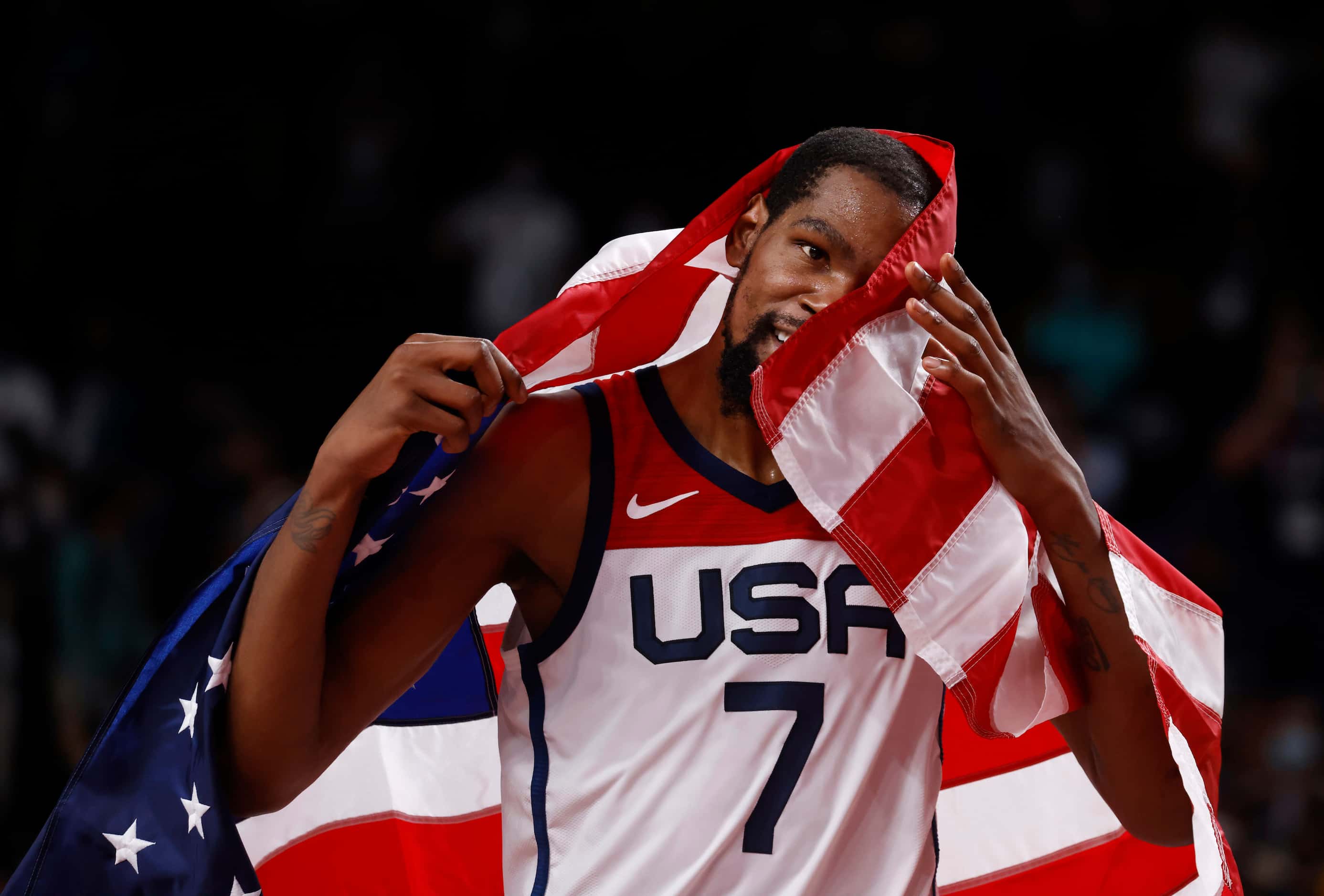 USA’s Kevin Durant (7) drapes a flag around himself in celebration after defeating France in...
