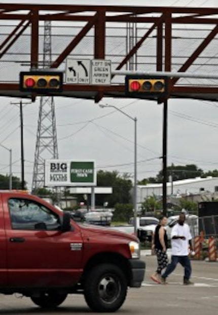  A man and woman are nearly hit by a car as they cross Harry Hines Boulevard at Walnut Hill...