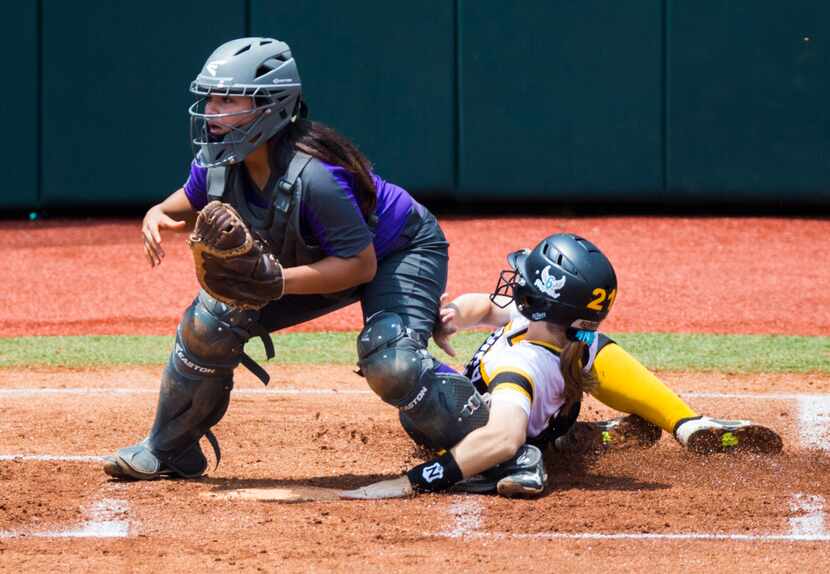 Forney's Charlie Hale (21) slides in to home for a run and collides with Angleton catcher...