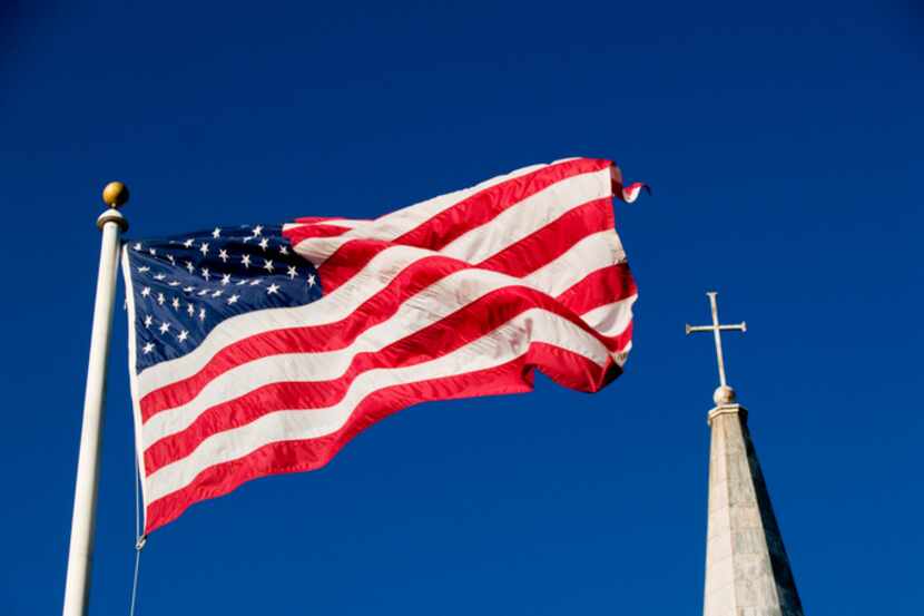 American flag and church steeple against very clear blue sky