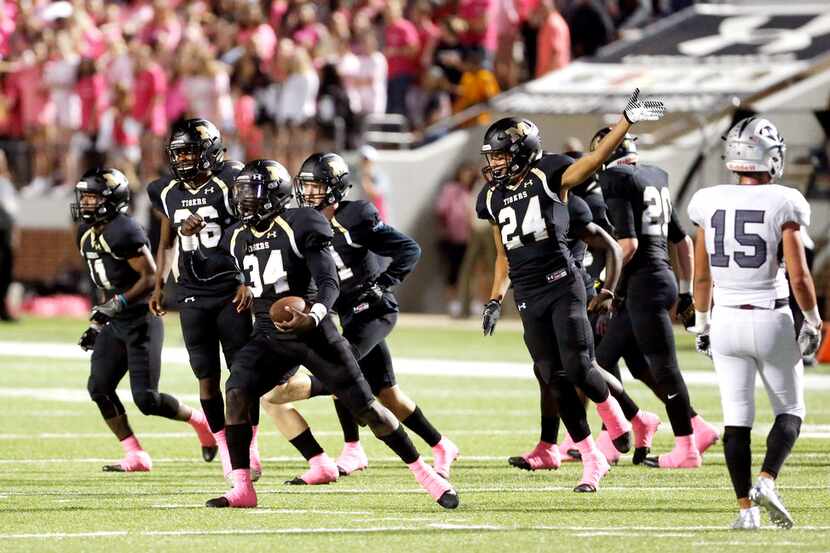 TXHSFB Mansfield senior defensive end Quincy Odom (34) celebrates recovering a fumble by...