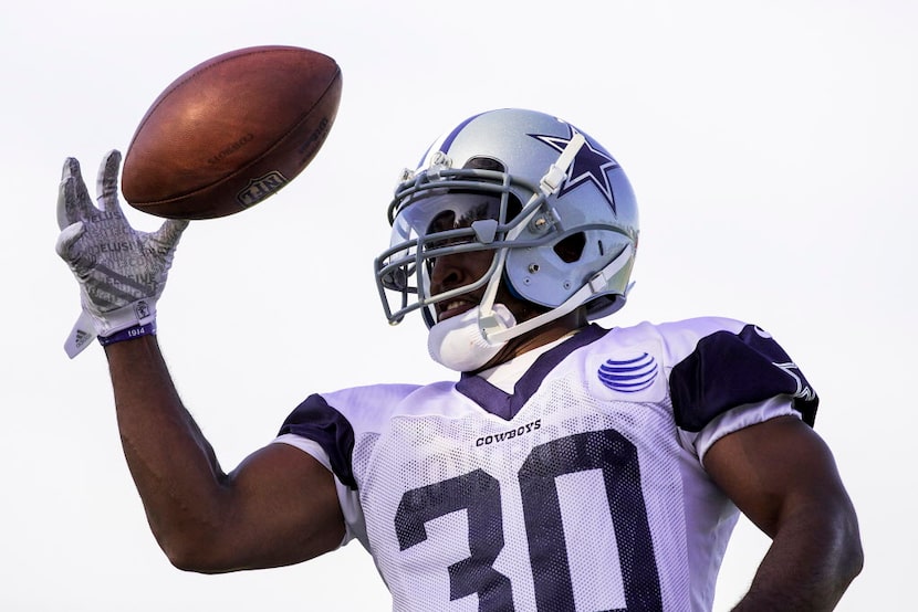 Dallas Cowboys running back Lache Seastrunk reaches for a ball during afternoon practice at...