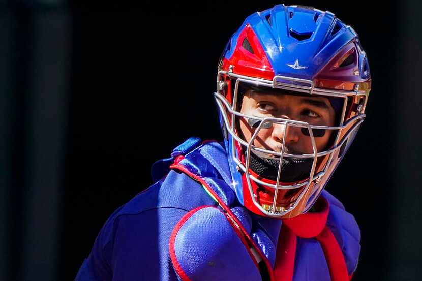 Texas Rangers catcher Jose Trevino looks to the dugout for a sign during the third inning of...