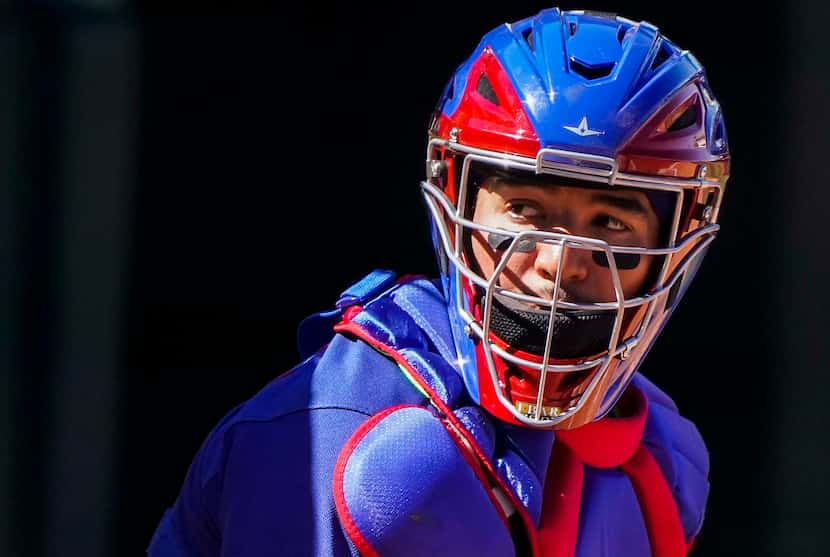 Texas Rangers catcher Jose Trevino looks to the dugout for a sign during the third inning of...