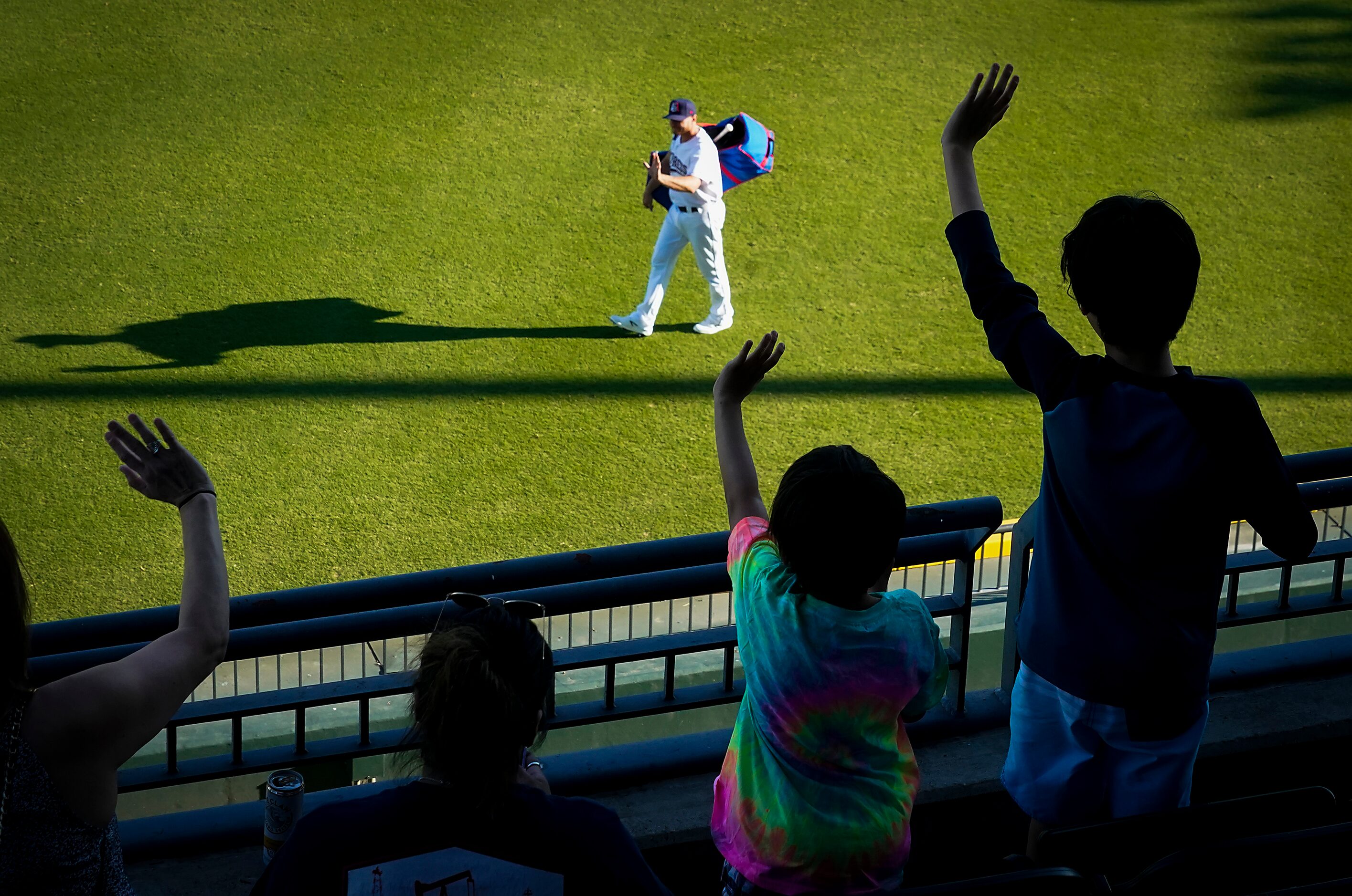 Fans wave to Round Rock Express catcher John Hicks as he takes the field to warm up at Dell...