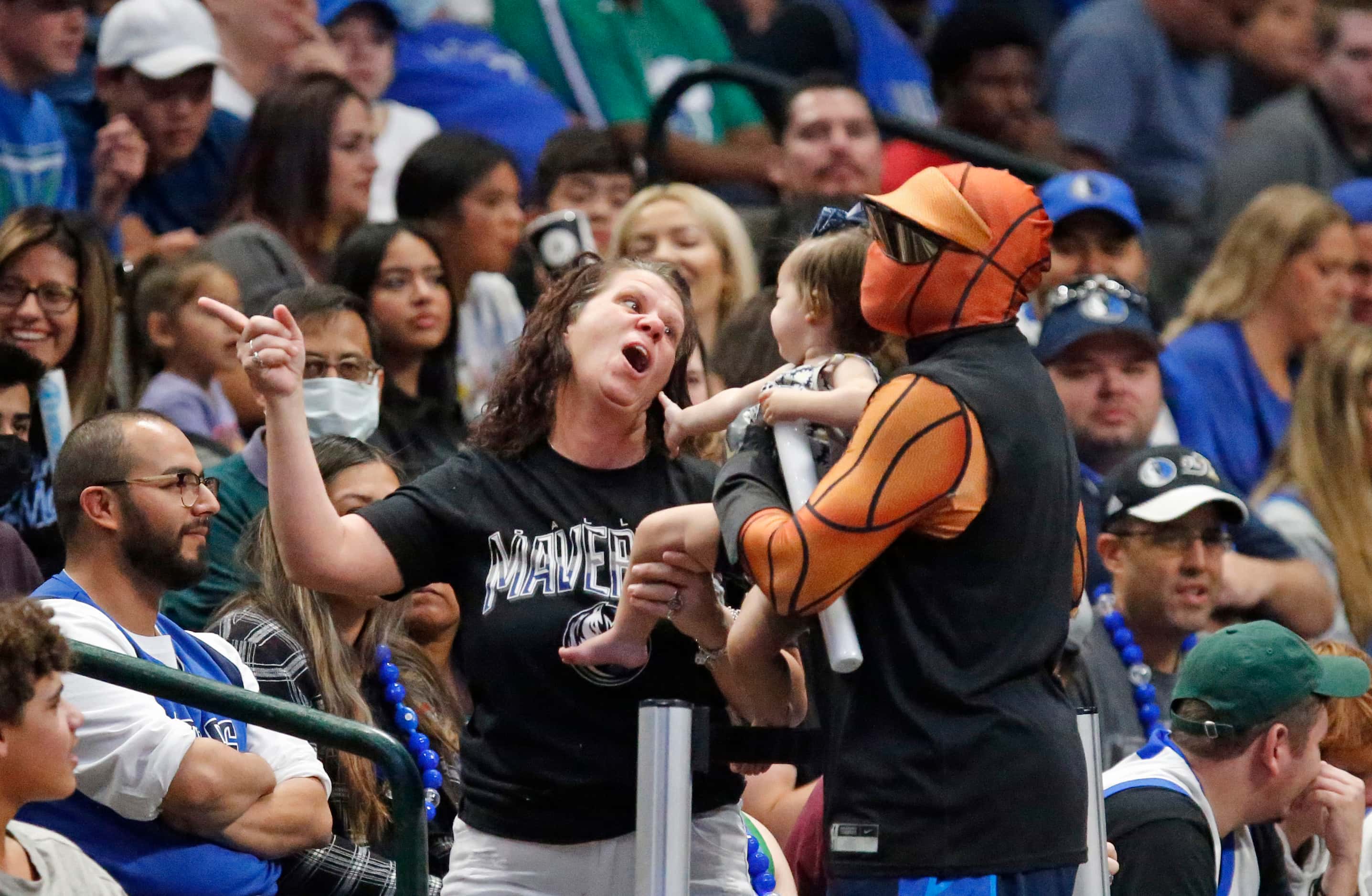 Mavs Man posed for pictures with babies at the Mavs Fan Jam, a free scrimmage for the fans...