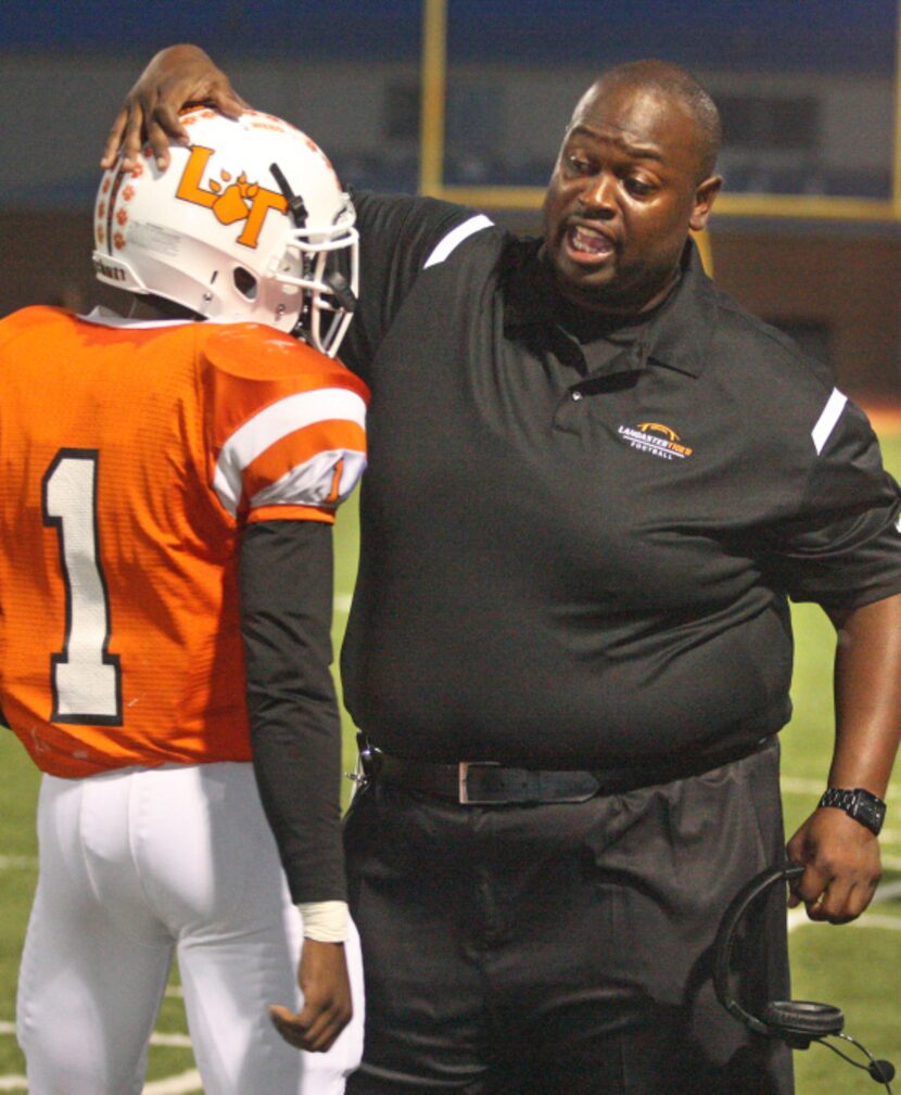 Lancaster head football coach Chris Gilbert (right) greets his quarterback Demarcus Ayers...