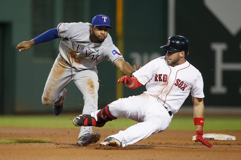 Texas Rangers' Elvis Andrus, left, tags out Boston Red Sox's Travis Shaw, who tried to...