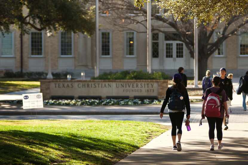 Students at Texas Christian University walk across University Boulevard on campus.