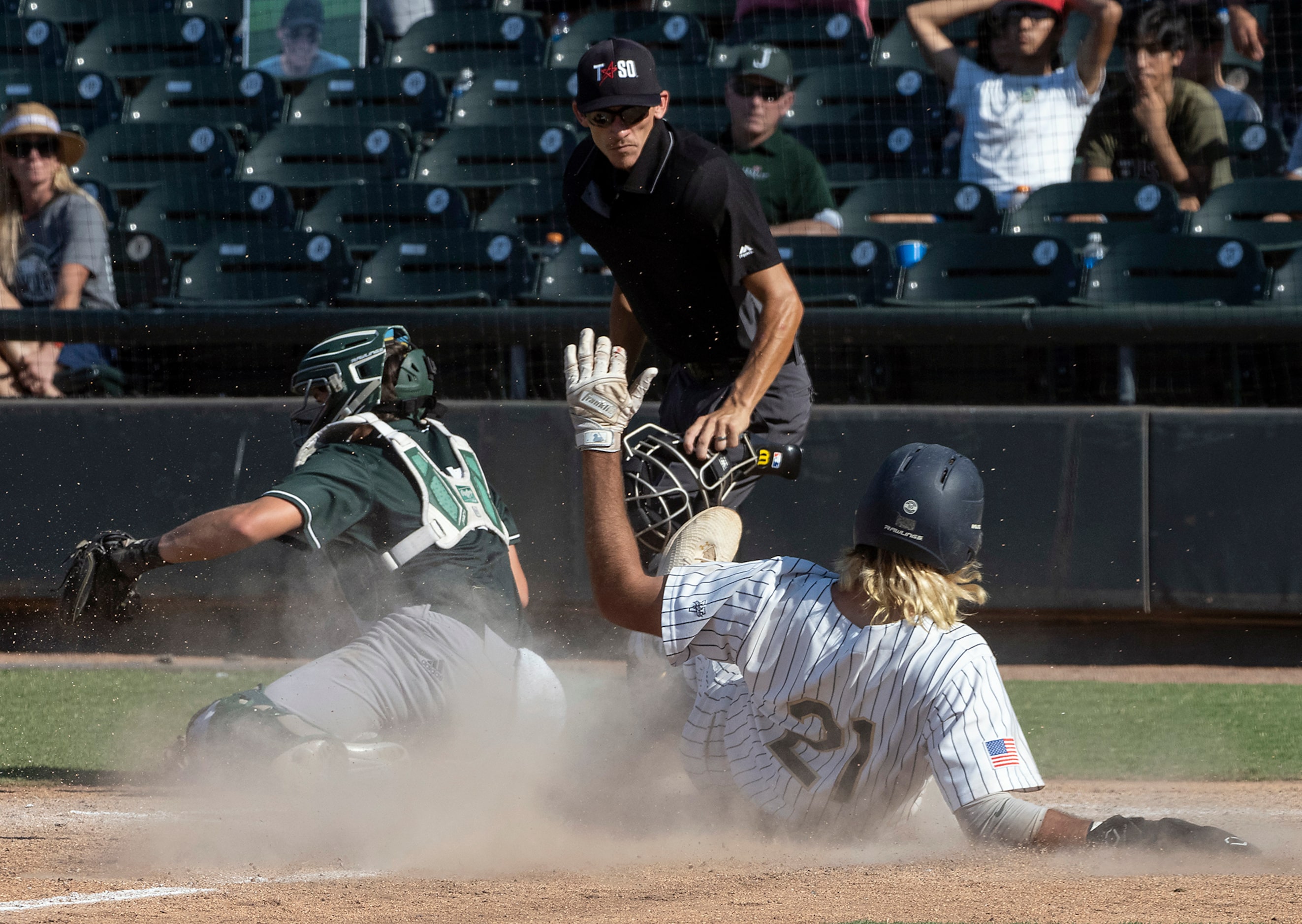 Keller Gray Rowlett, (21), slides safely into home plate as Houston Strake Jesuit catcher,...